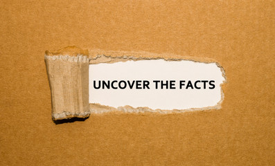 The phrase Unkover the facts written insight brown torn paper.