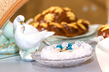 Gold wedding rings on a crystal plate in the registry office before the ceremony, family, wedding traditions and mural wedding in blue style, 