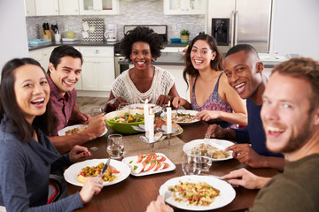Portrait Of Friends Enjoying Dinner Party At Home