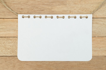 Blank notebook sheet with rope on wood background