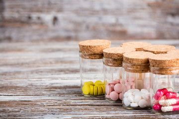Various pills and capsules in containers with caps