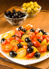 salad with cherry tomatoes and olives on wooden