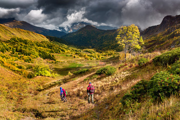 Obraz premium A group of tourists coming down the hill in the Caucasus mountains in autumn