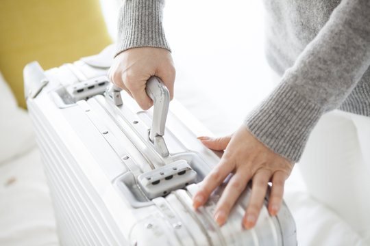 Woman is trying to lift the suitcase