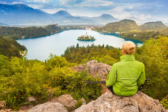 Young spoty active lady with hiking sticks admires beautiful nature around Bled Lake in Julian Alps, Slovenia. 