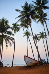 Obraz na płótnie Canvas Sunset on a tropical beach with a boat
