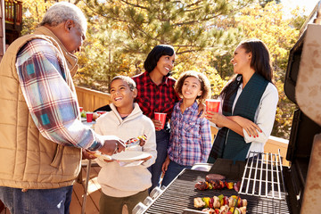 Grandparents With Children Enjoying Outdoor Barbecue