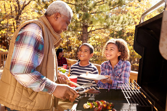 Grandparents With Children Enjoying Outdoor Barbecue