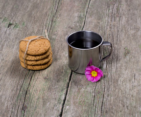 the steel cup of coffee decorated with a flower and a linking of