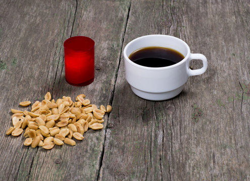 coffee, peanut and red candle, on a wooden table