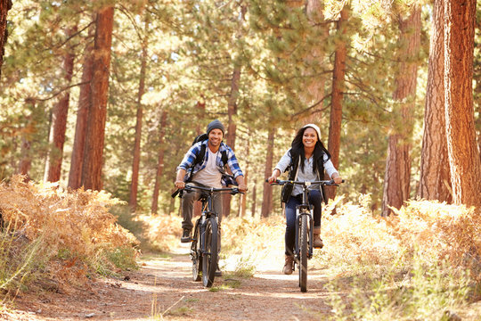 African American Couple Cycling Through Fall Woodland