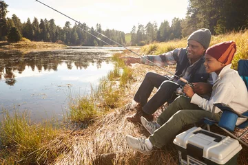 Abwaschbare Fototapete Angeln Großvater bringt seinem Enkel bei, am See zu fischen