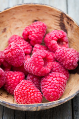 Frozen raspberries on wooden background.