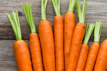 Fresh carrots bunch on rustic wooden background.