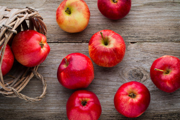 Ripe red apples on wooden background.