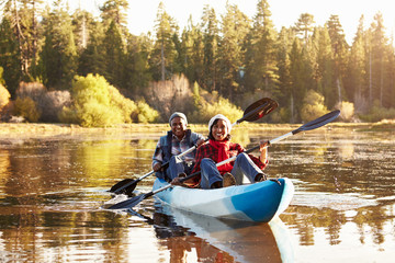 Fototapeta na wymiar Senior African American Couple Rowing Kayak On Lake