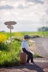 Little boy with suitcase and map, traveling