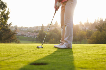 Fototapeta premium Close Up Of Male Golfer Lining Up Putt On Green