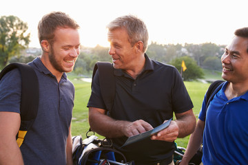 Group Of Male Golfers Marking Scorecard At End Of Round