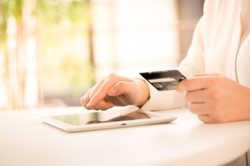 Hands of an office woman typing keyboard with credit card