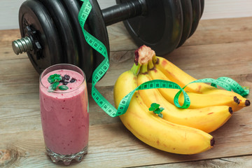 Naklejka premium smoothies and a bunch of bananas, a dumbbell in the background