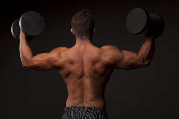 Fototapeta na wymiar naked muscular man posing with weights