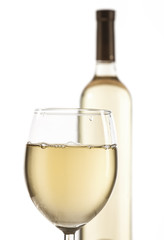 Wineglass and bottle with white wine