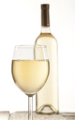 Wineglass and bottle with white wine