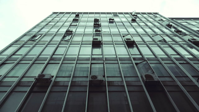Passing by old abandoned urban building scyscraper offices tracking shot.Gimbal stabilized