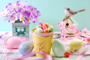 easter pastel colors decoration with candy eggs in small bucket