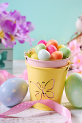 easter pastel colors decoration with candy eggs in small bucket