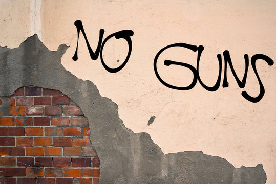 Handwritten graffiti No Guns sprayed on the wall, anarchist aesthetics 