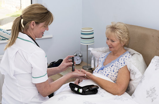 Nurse Showing Patient How To Test Blood With A Finger Prick Device