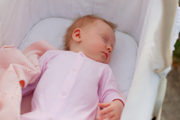 Newborn baby girl sleeping/Cute newborn baby girl sleeping in a cradle outdoors