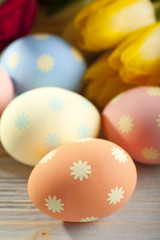 Tulip flowers and Easter eggs on wooden table