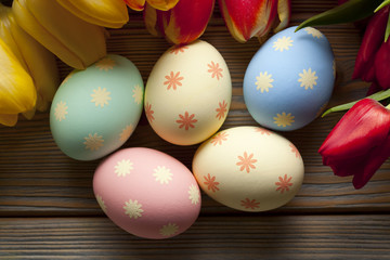 Easter eggs and flowers on wooden background
