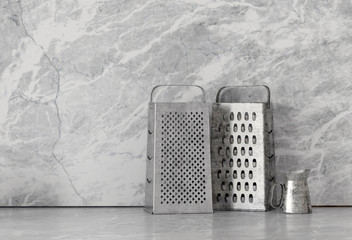 Metal food graters over marble background