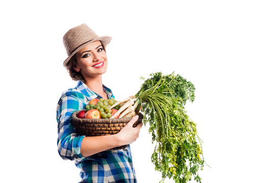 Woman, checked shirt holding basket with fruit and vegetables