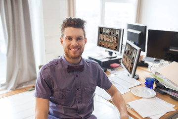 happy creative male office worker with computers