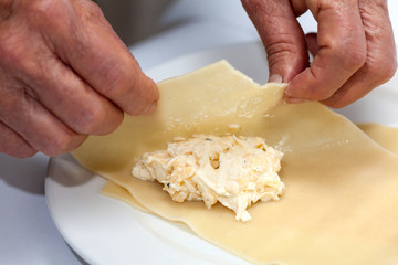 Doblando los triángulos rellenos para la lasagna parmesana