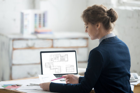 Female Architect Reading Blueprints