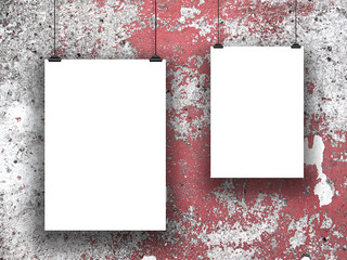 Close-up of two hanged asymmetrical paper sheet frames with clips on scratched wall background