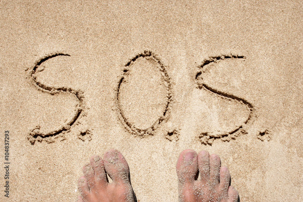 Fototapete concept or conceptual s.o.s. text handwritten in sand on a beach in an exotic island background