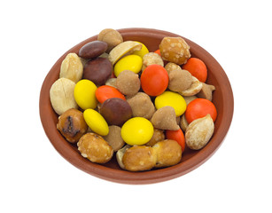 Peanut butter chips and candy trail mix in a small bowl isolated on a white background.
