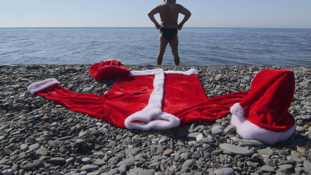 Man dressed as Santa Claus going to swim in the sea
