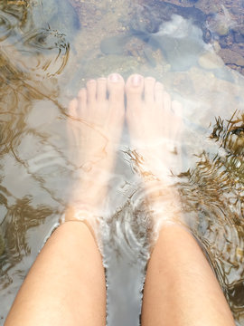 Female relaxing her feet in canal. Travel concept