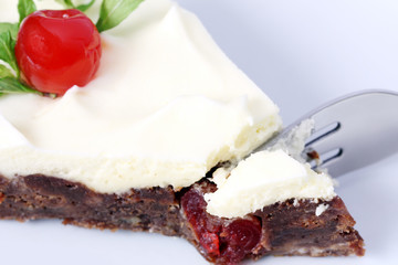 eating bite of served slice of delicious chocolate brownie cake with cherry