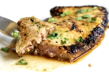 served delicious piece of tuna steak with greenery and dinnerware
