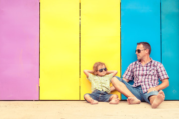 Father and son relaxing near the house at the day time.