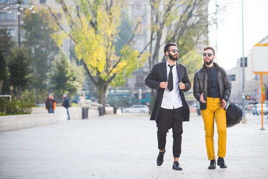 two young bearded blonde and black hair modern businessman, walk